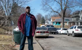 Black man on street sidewalk looking at camera